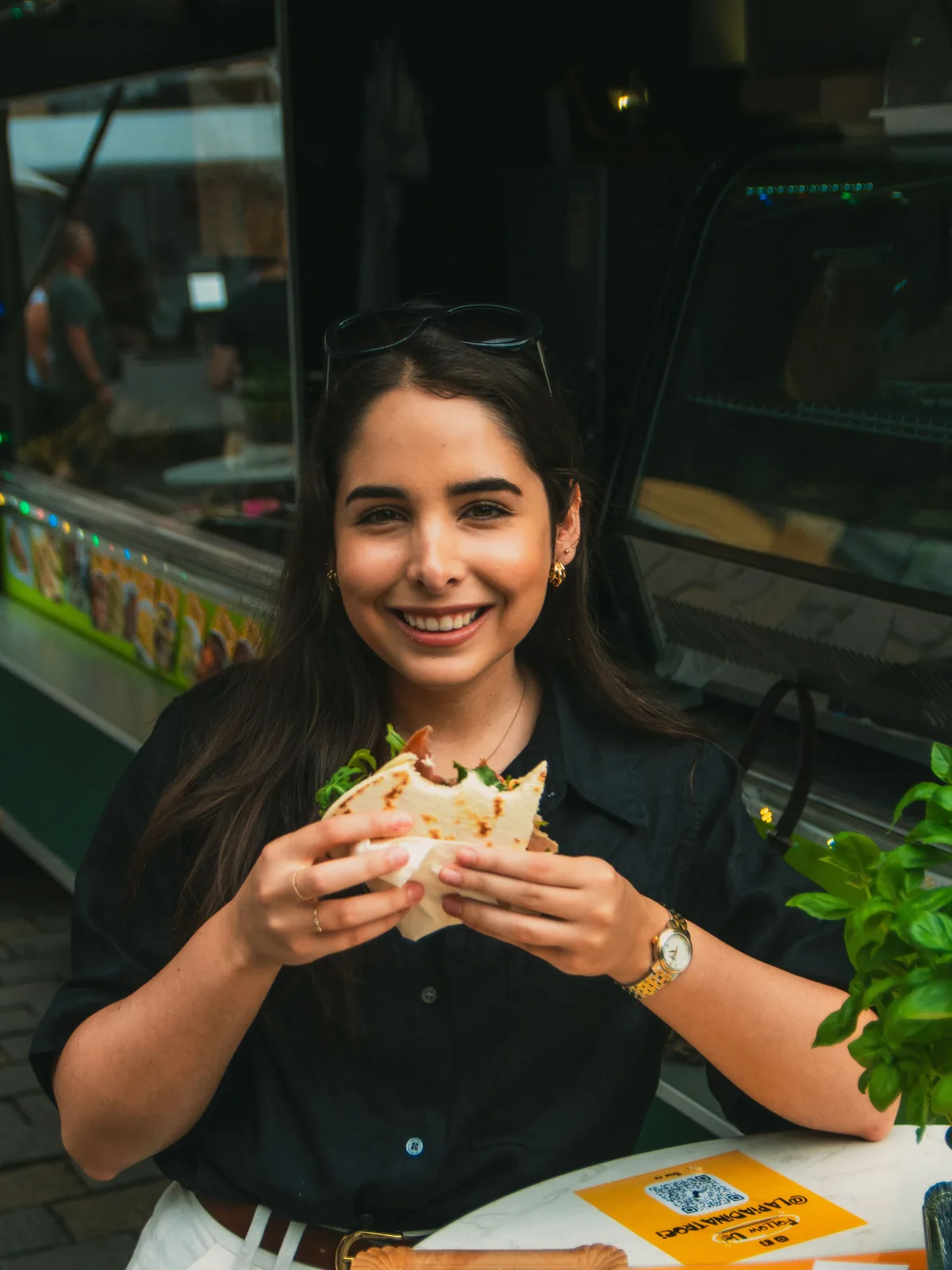 Woman holding a sandwich at a cafe