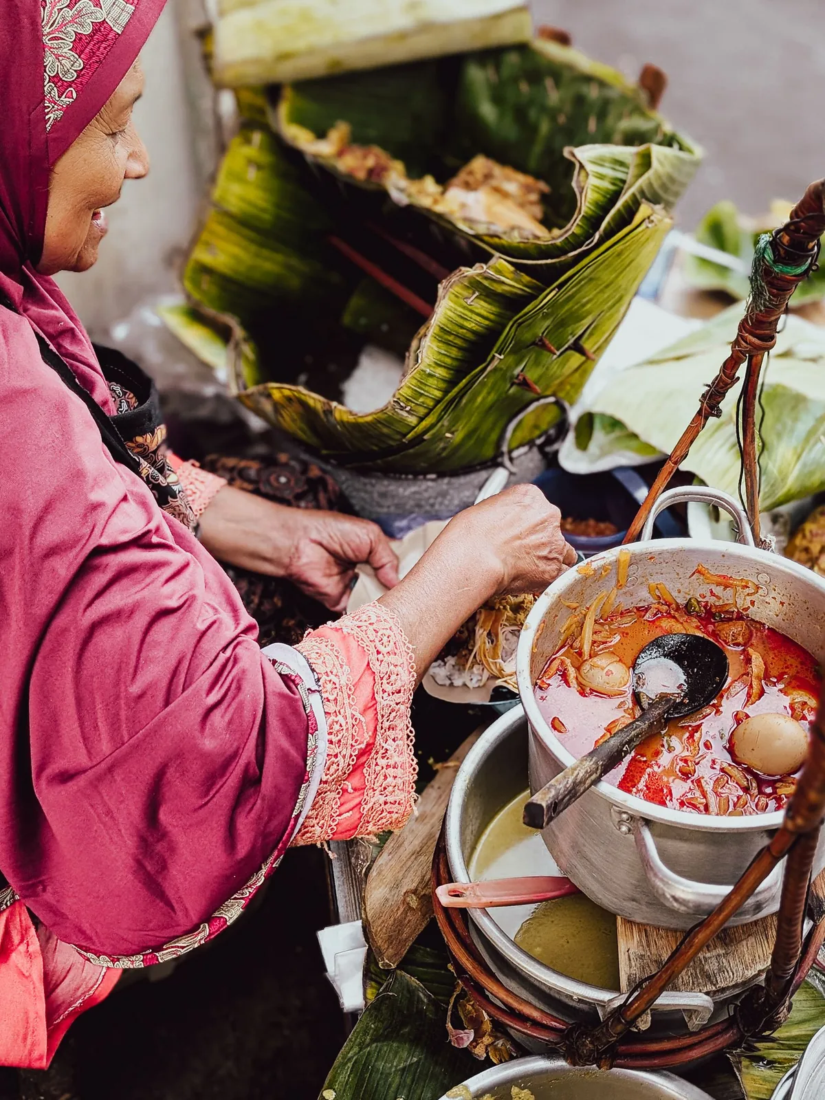 Hands holding wrapped Indonesian street food