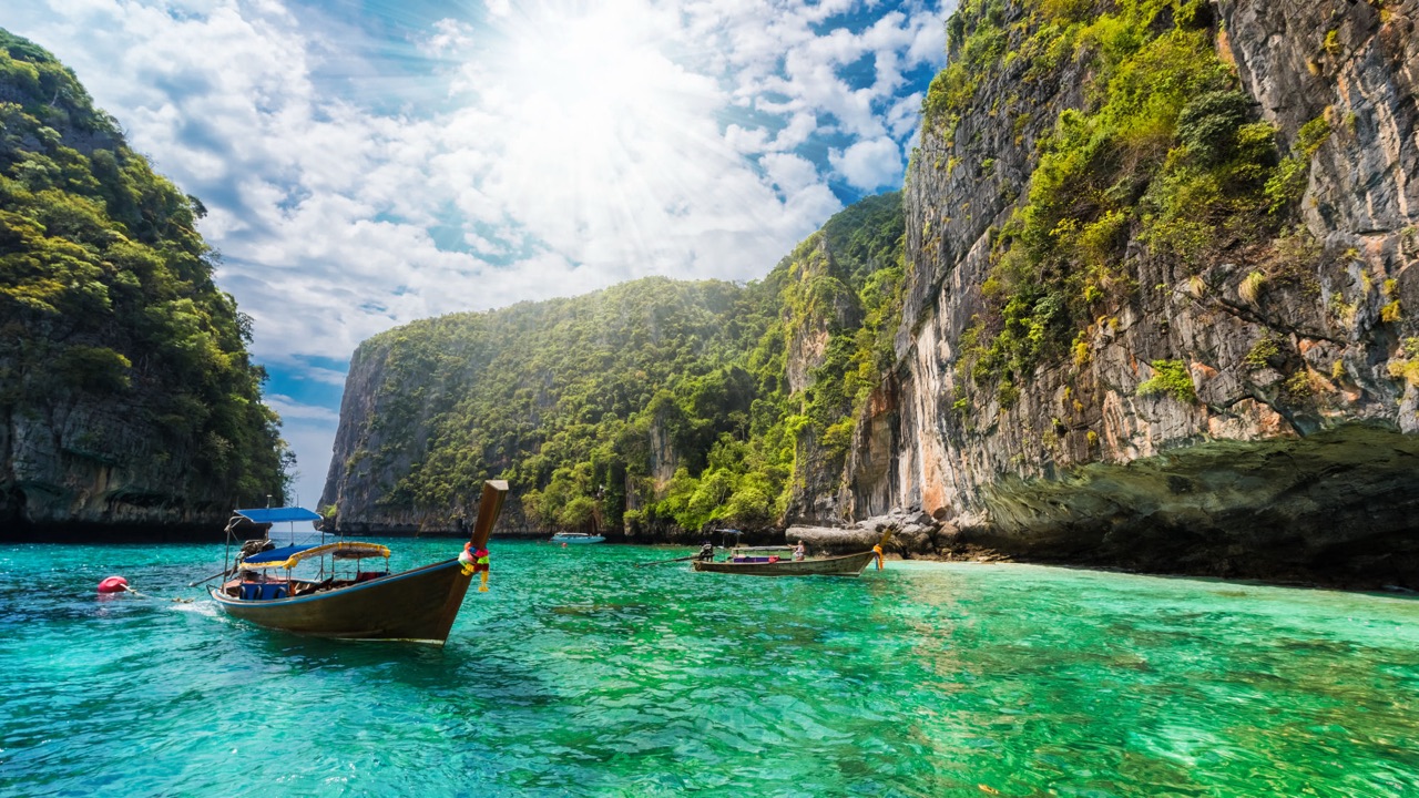 Longtail boats among limestone islands in turquoise water near Phuket
