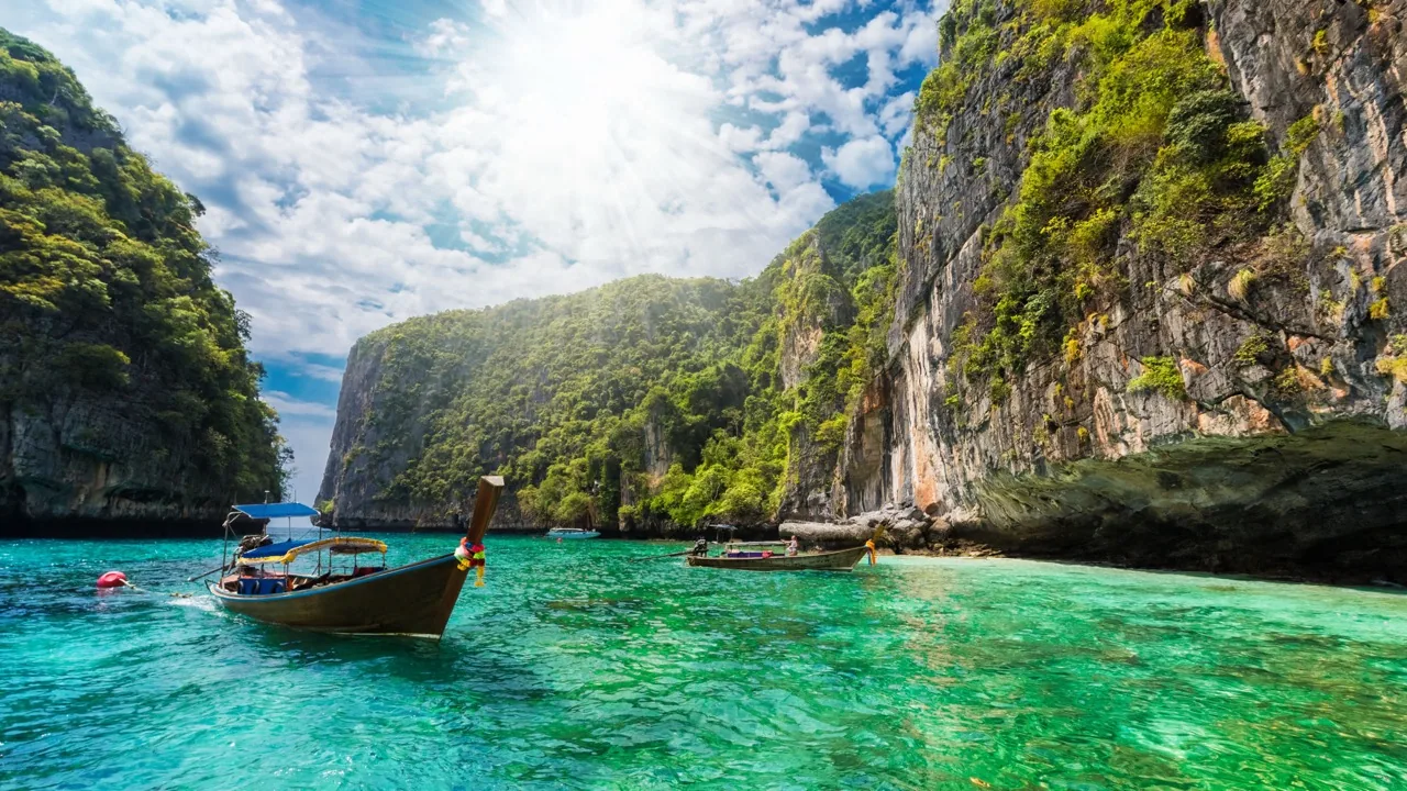 Longtail boats among limestone islands in turquoise water near Phuket