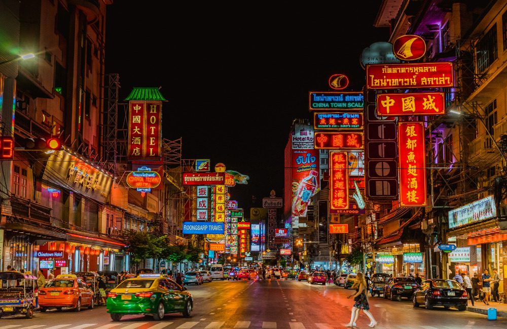 Night market in Bangkok's Yaowarat Chinatown with food stalls lit by warm lantern light