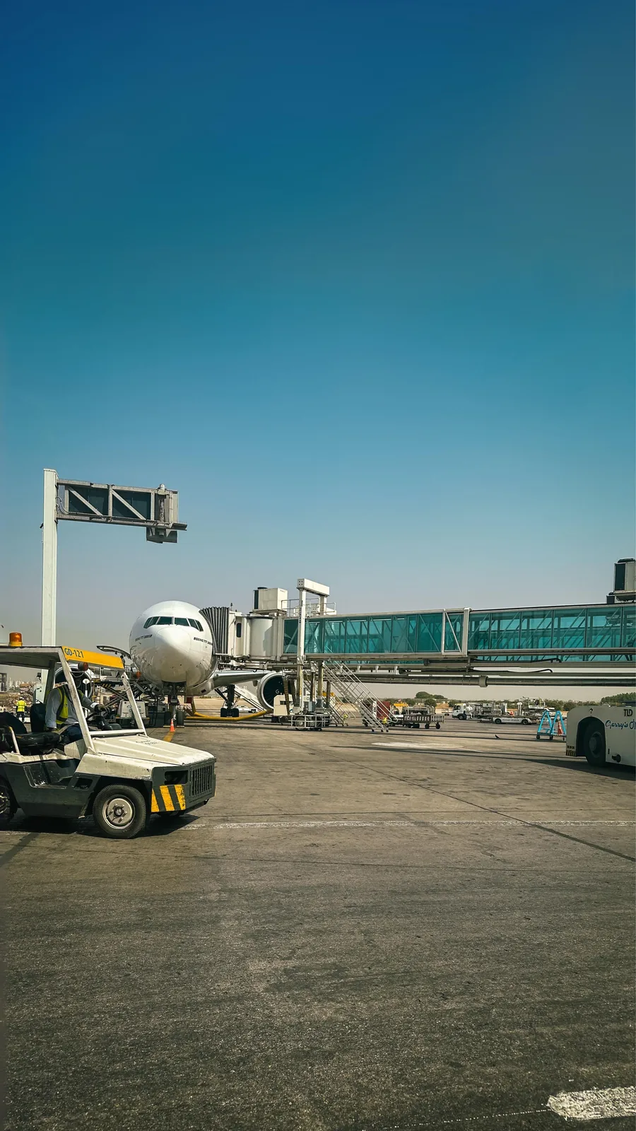 Airport tarmac with a ground vehicle beside a plane