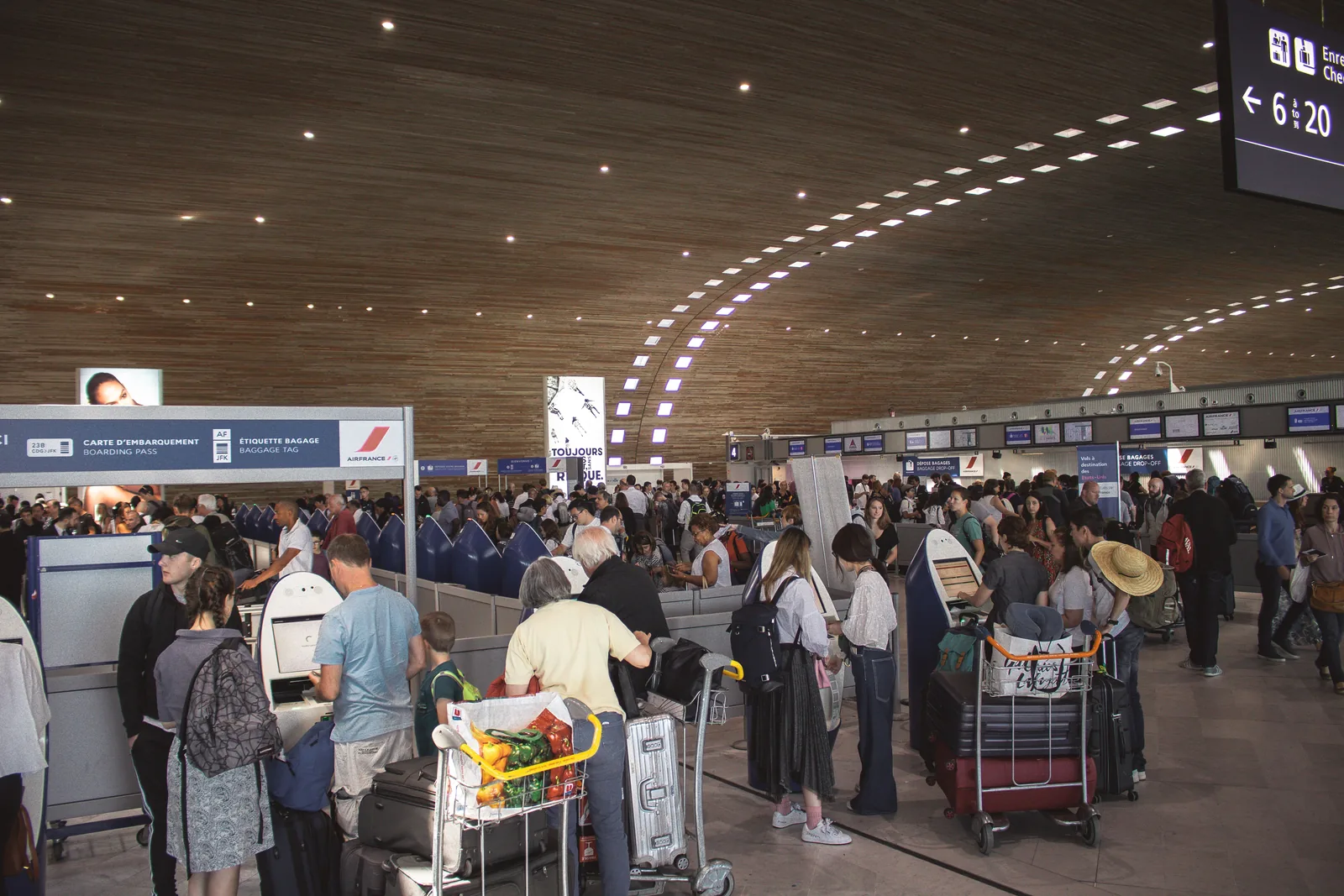 Busy airport terminal with travelers and luggage carts