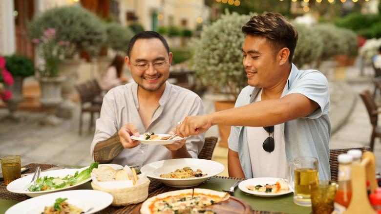 Travelers eating together at a restaurant while traveling abroad